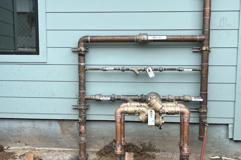 Copper repipe manifold with new shutoff valves installed on the exterior of a San Diego home