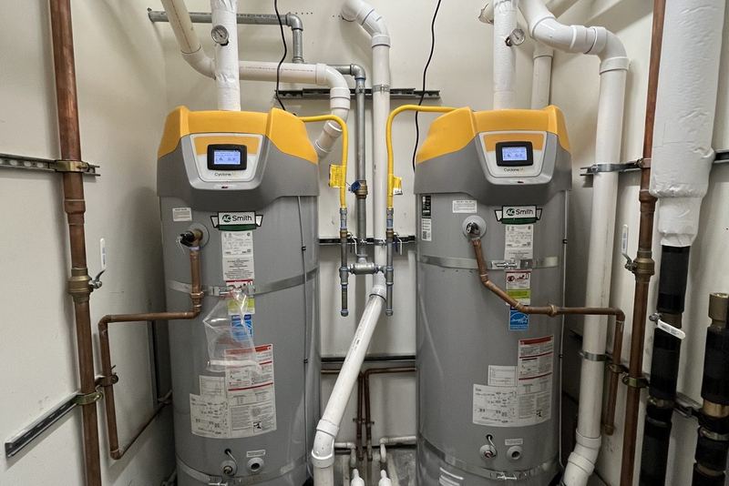 Two water heaters installed side by side with new copper supply piping
