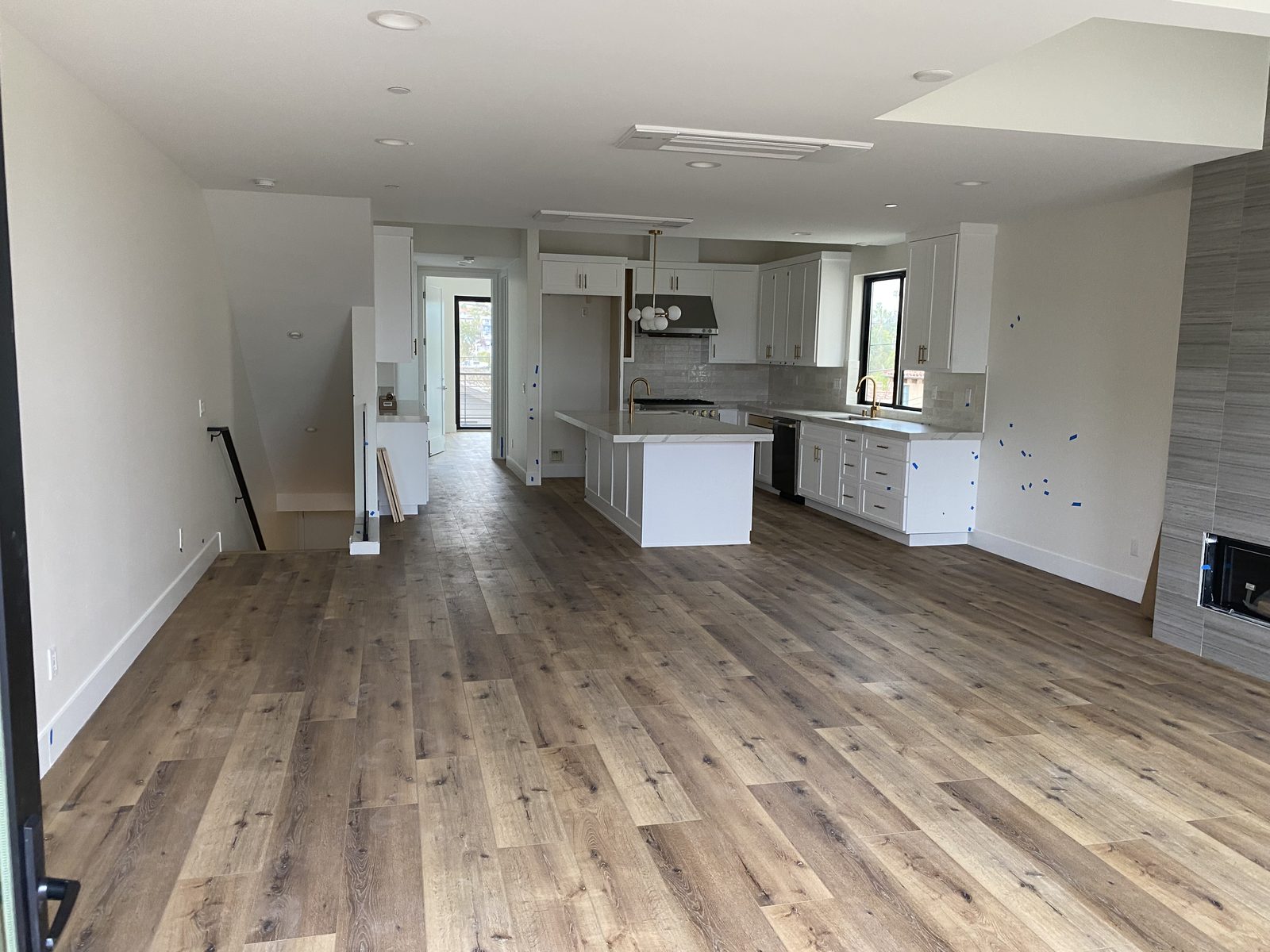Open kitchen and living area of a new construction home after the plumbing was finished