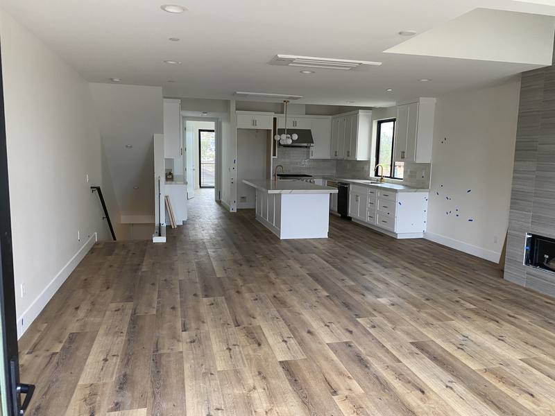 Open kitchen and living area of a new construction home after the plumbing was finished