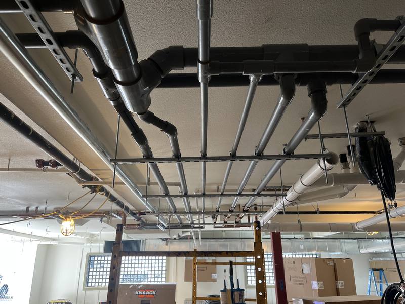 Overhead waste and water piping rough-in in a commercial building
