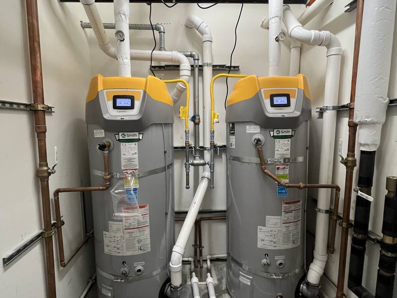 Two commercial water heaters installed side by side with new copper supply piping