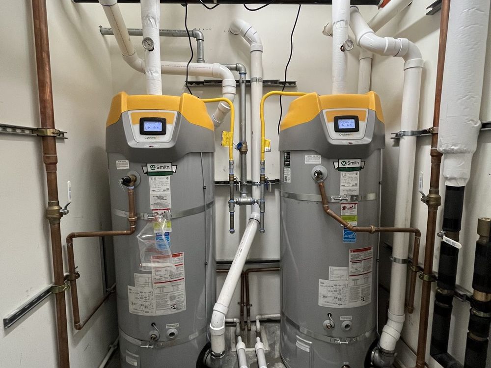 Two water heaters installed side by side with new copper supply piping