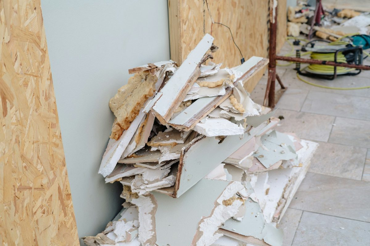 Pile of torn-out drywall and framing scrap on a job site, ready to be hauled away